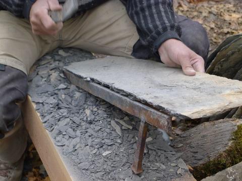 La taille d’une lauze pour la restauration de la toiture de la chapelle des Roranches © R. Papet - PNE