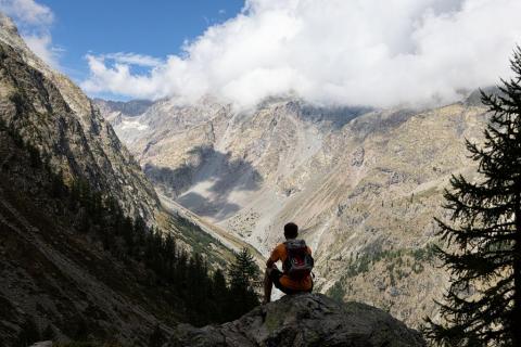 Un randonneur assis devant un paysage de montagne