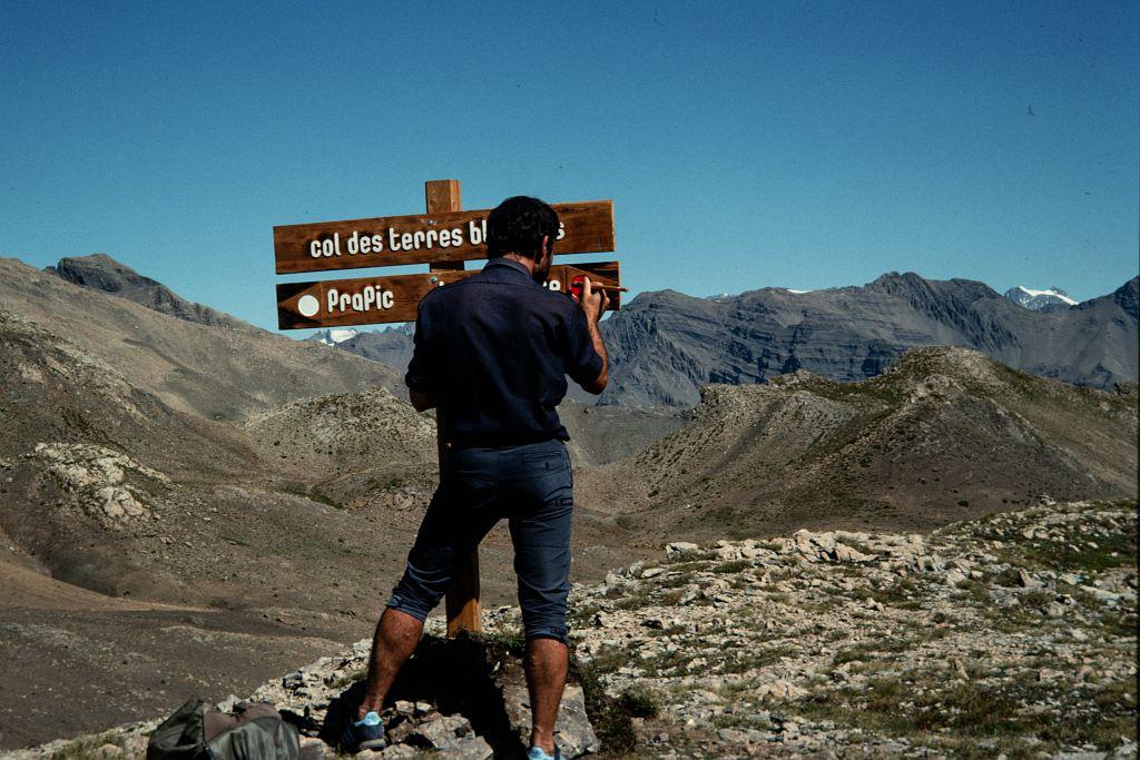 Signalétique - garde-moniteur peignant le panneau indiquant le col des Terres blanches © PNE