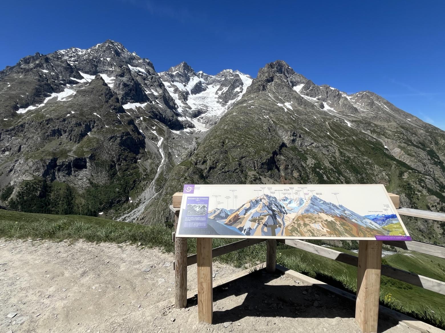 Table d'orientation devant une montagne