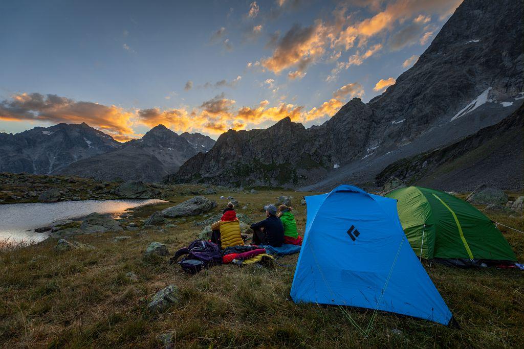 Tente et bivouaqueurs au bord d'un lac de montagne