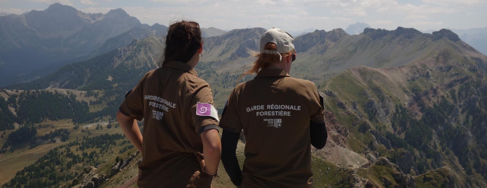 deux personnes de dos regardent un paysage de montagne